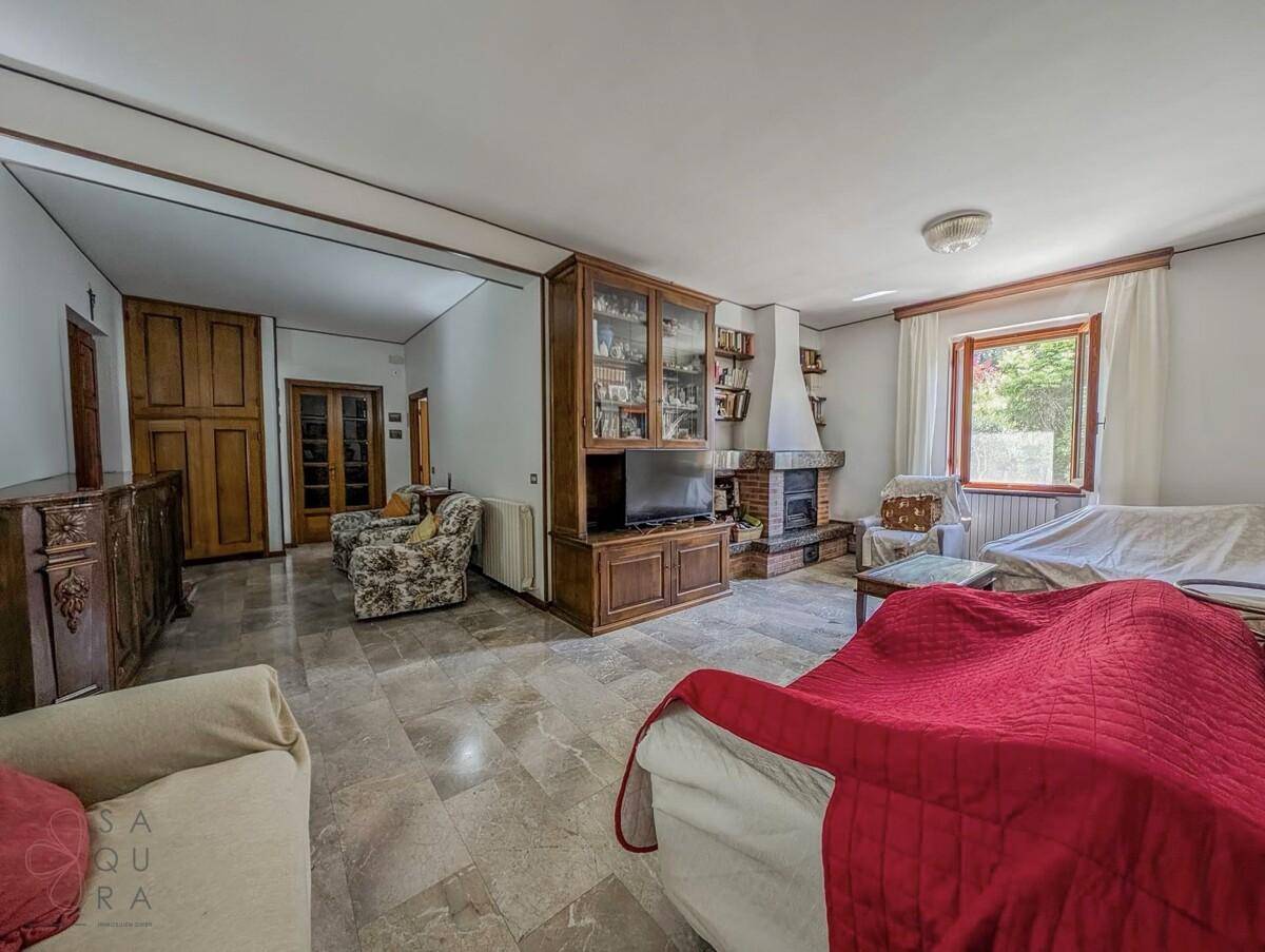 Gemütliches Wohnzimmer mit Marmorboden, Kamin und traditionellen Holzmöbeln.