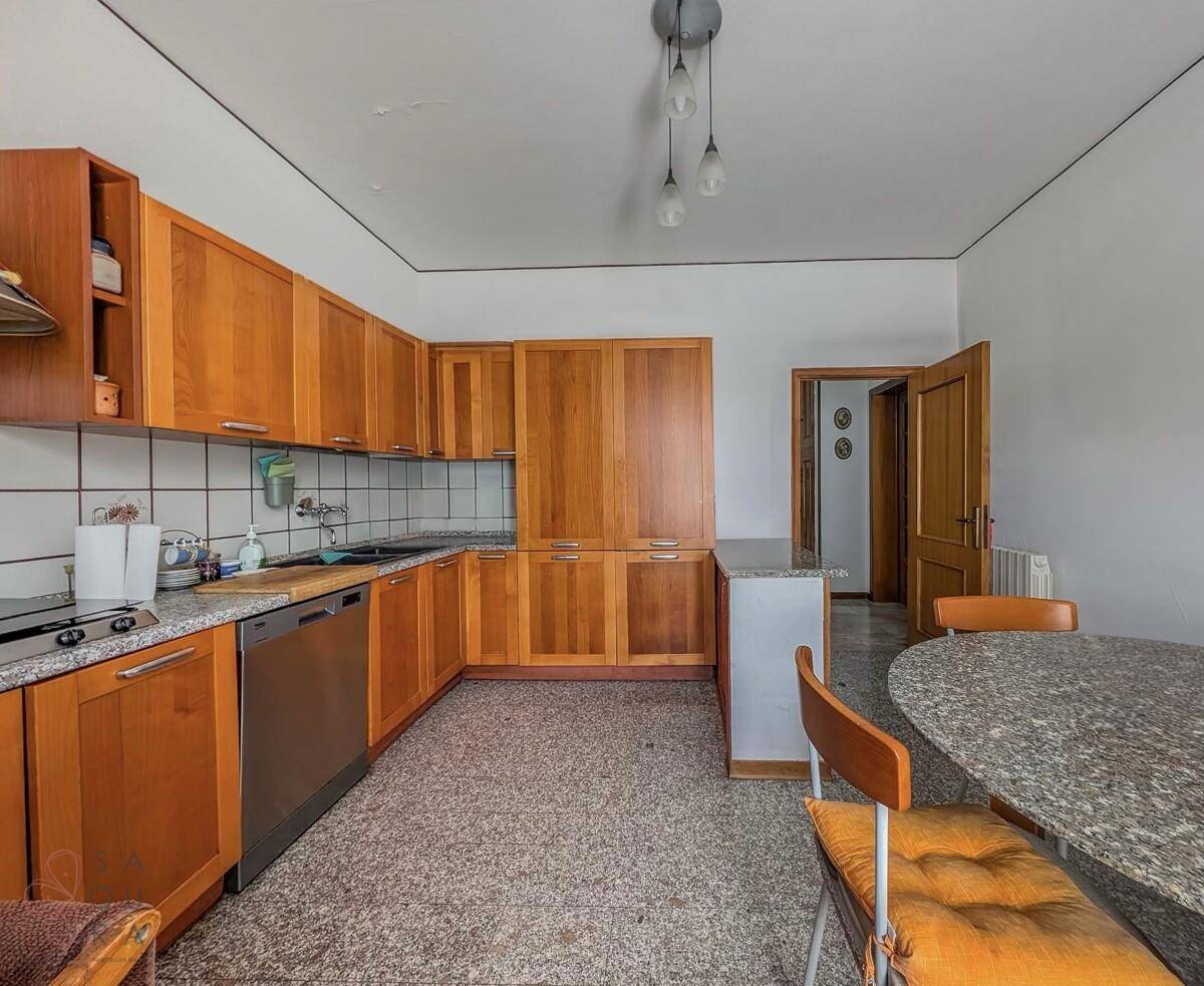 Traditionelle Küche mit Holzschränken, Granitarbeitsplatten und einem Essbereich.