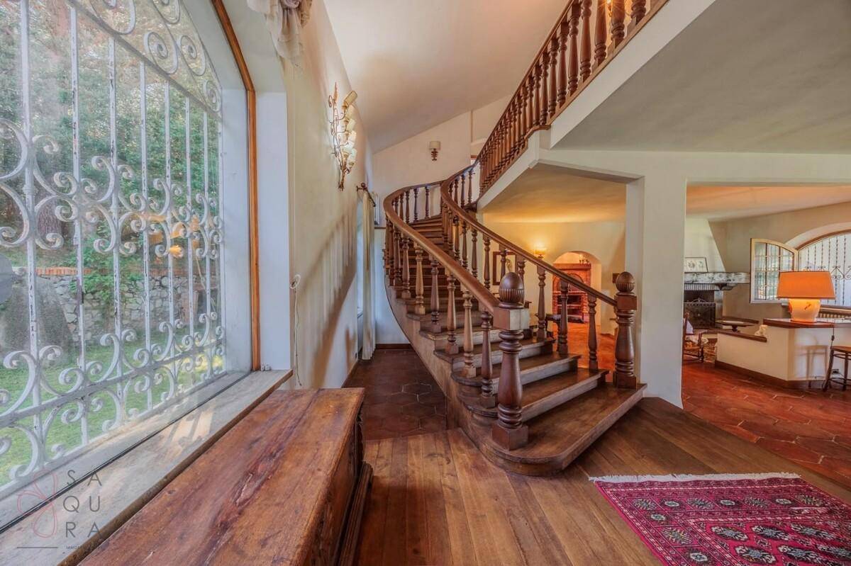Flur mit eleganter Holztreppe und Fischgrätparkettboden.