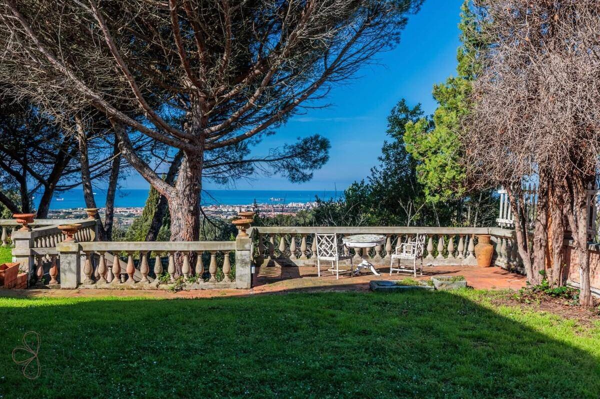 Gartenbereich mit Balustrade, Sitzgelegenheiten und malerischem Meerblick.