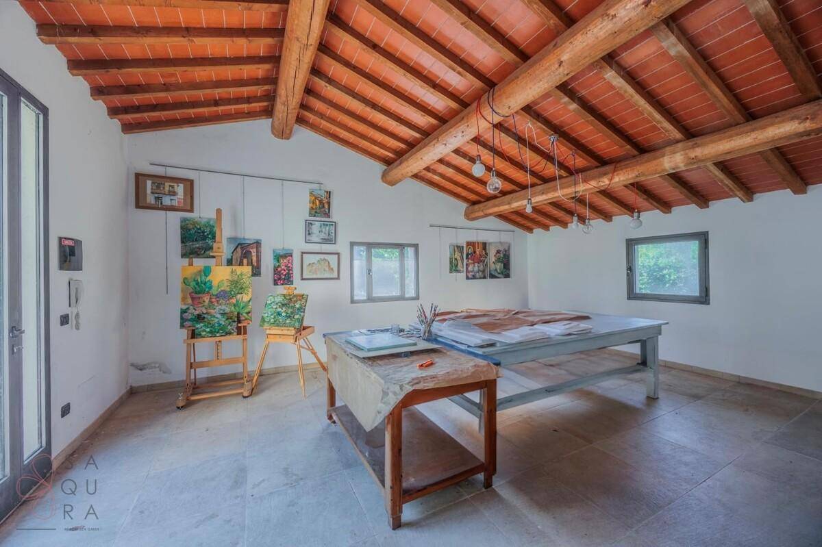 Kreativer Arbeitsraum mit hohen Decken, Holzbalken und viel Tageslicht, ideal für Künstler.