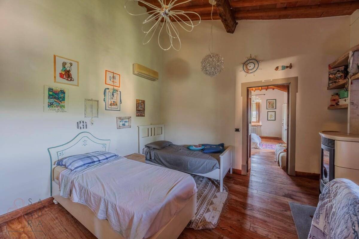 Helles Schlafzimmer mit zwei Einzelbetten, Holzboden und Klimaanlage, gemütlich eingerichtet.