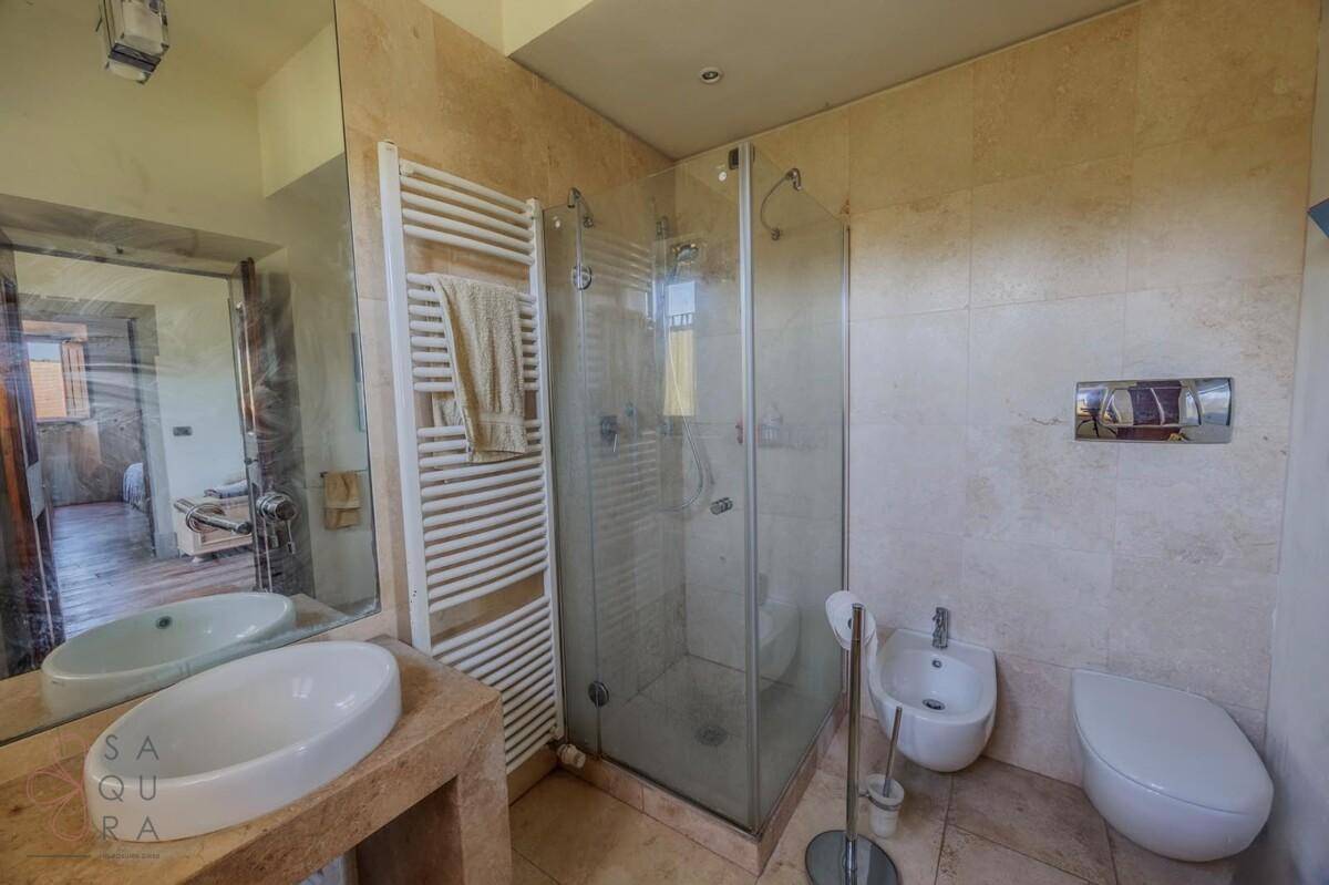 Modernes Badezimmer mit begehbarer Dusche, Bidet und beheiztem Handtuchhalter, in hellen Tönen gehalten.