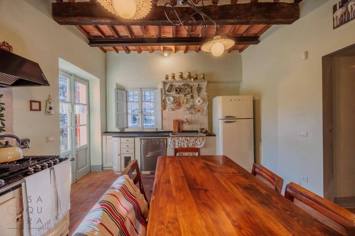 Geräumige Küche mit Spülmaschine, Retro-Kühlschrank und viel natürlichem Licht durch die Fenster.