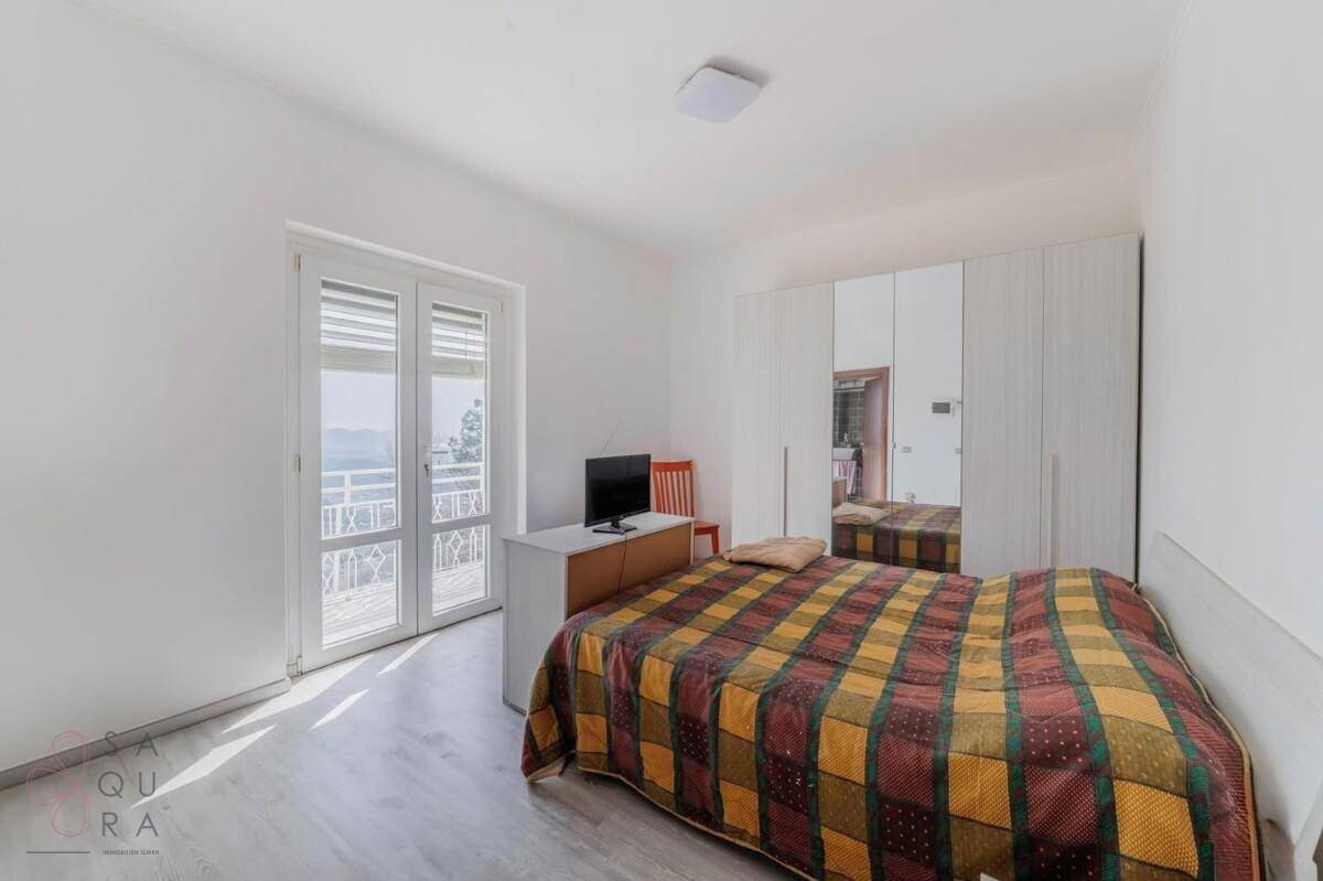Schlafzimmer mit Doppelbett, Spiegelschrank und Balkonzugang, hell und geräumig.