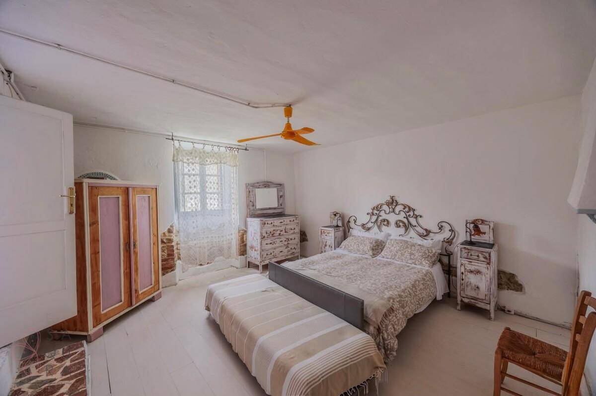 Geräumiges Schlafzimmer mit weiß gestrichenem Holzboden und traditionellen Möbeln.