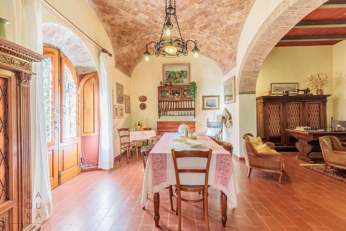 Eleganter Essbereich mit Ziegelgewölbedecke, Terrakottaboden und antiken Holzmöbeln, lichtdurchflutet.