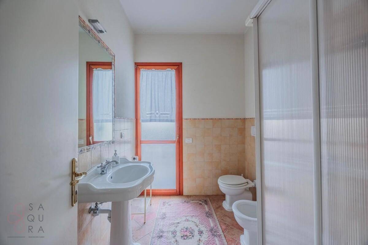 Badezimmer mit Waschbecken, WC, Bidet und einer Duschkabine.