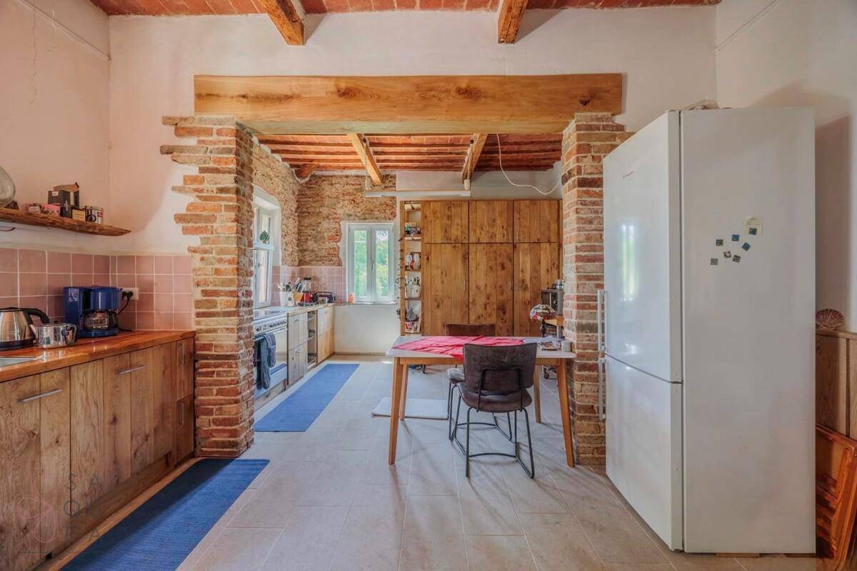 Traditionelle Küche mit Holzeinbauten, großem Kühlschrank und rustikalem Charme.