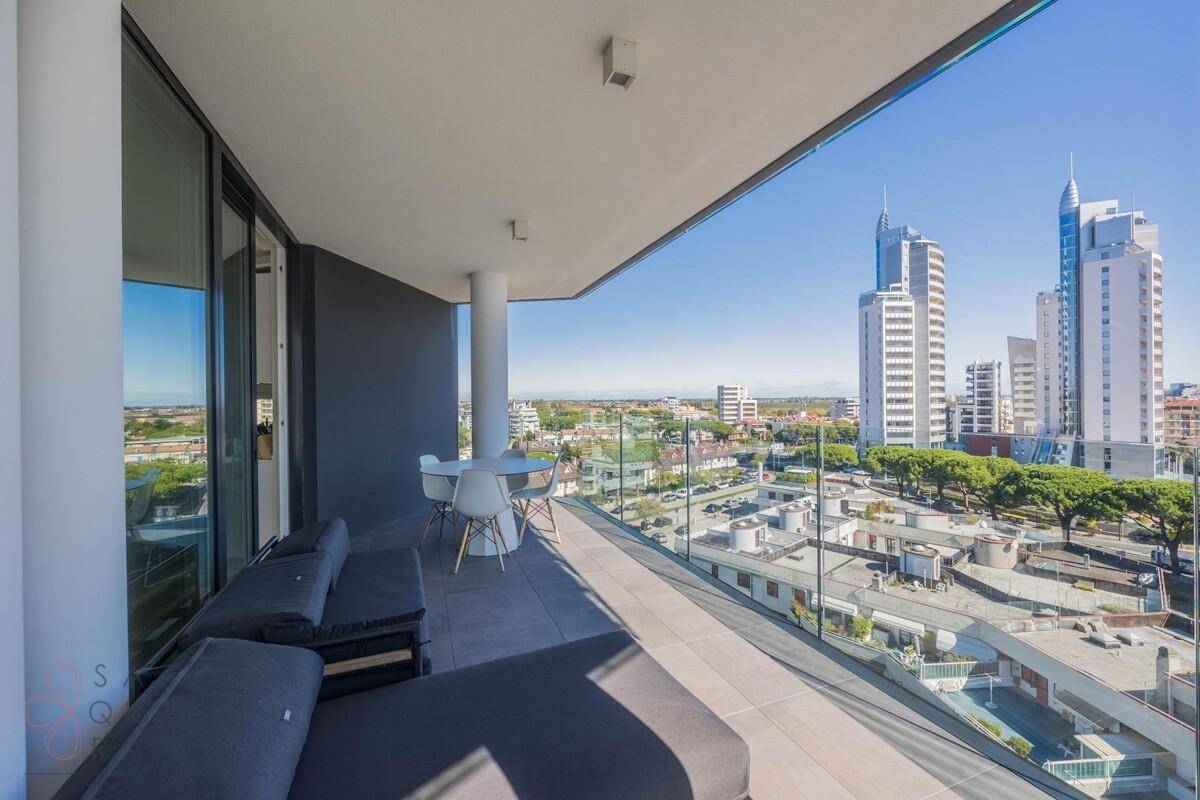 Langer Balkon mit Lounge-Möbeln und Panoramablick über die Stadt und die Umgebung.