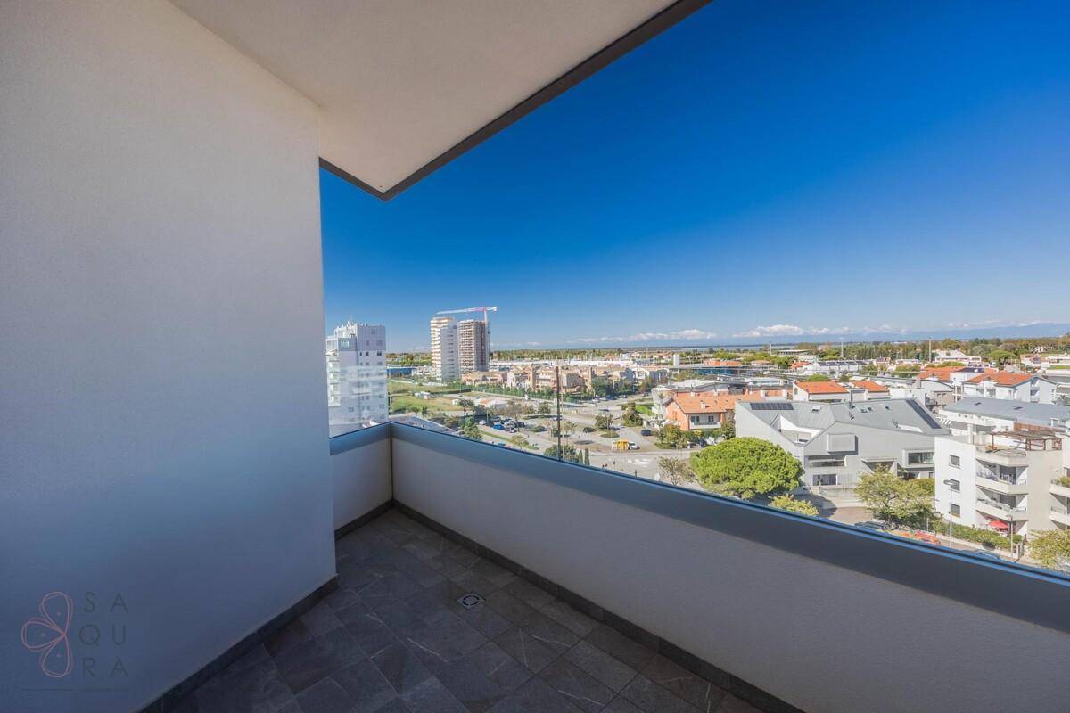 Kleiner Balkon mit Fliesenboden und weitem Blick über die Stadt und das Meer.