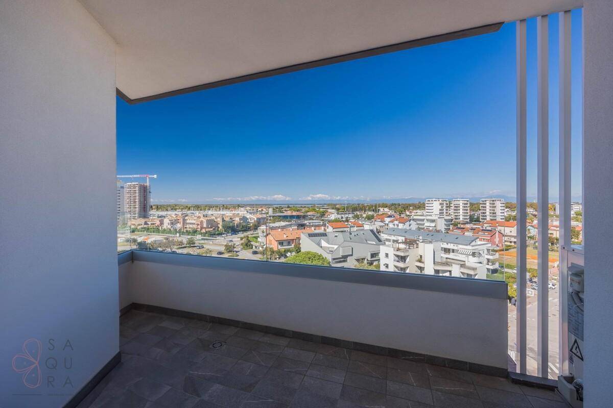 Balkon mit Fliesenboden und weitem Blick über die Stadt und die Küstenlinie.