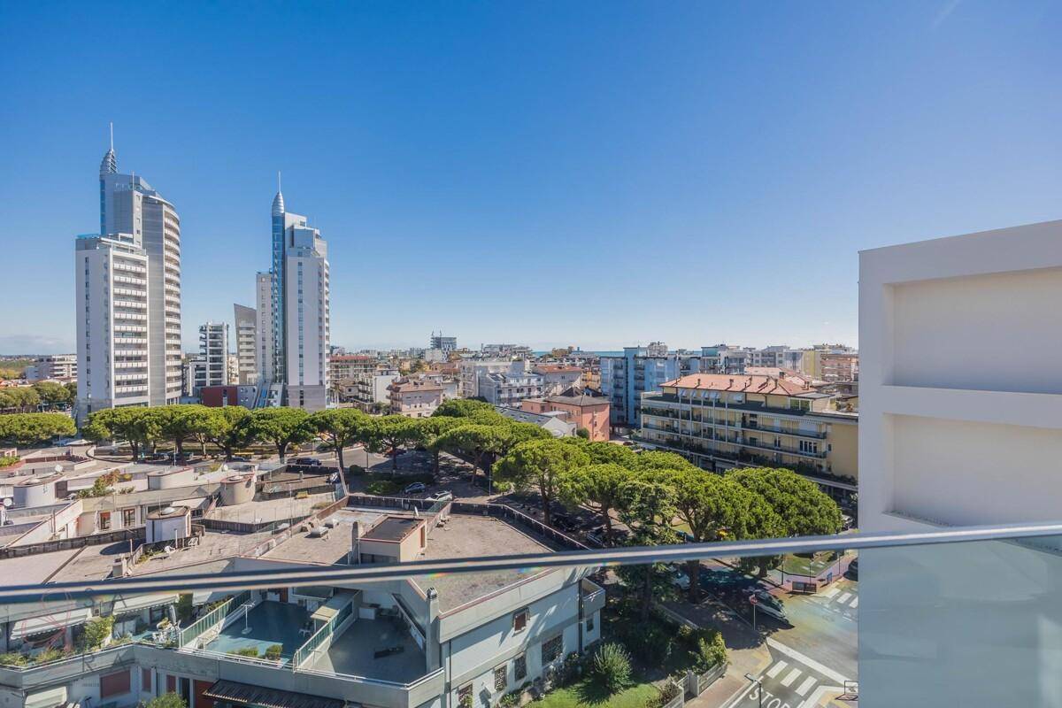 Panoramablick von einem Balkon über die Stadt mit modernen Hochhäusern und Grünflächen.