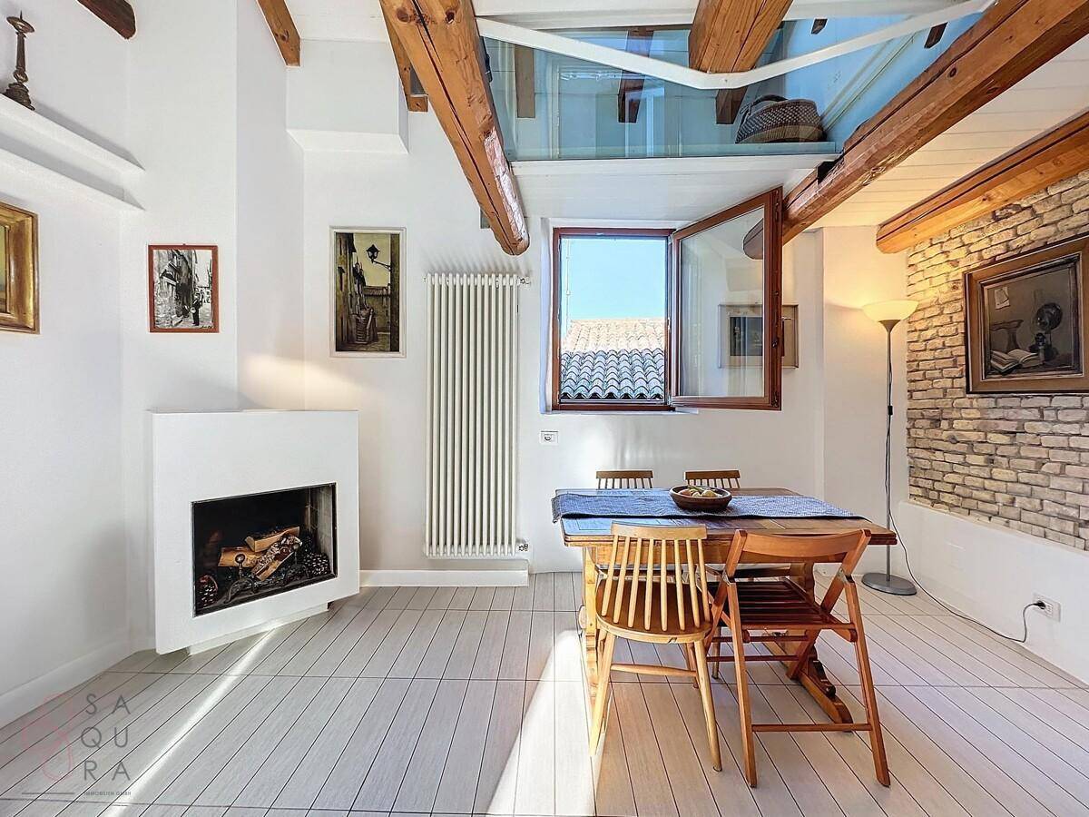 Gemütlicher Essbereich mit Holztisch, Kamin und viel Tageslicht durch das Dachfenster.
