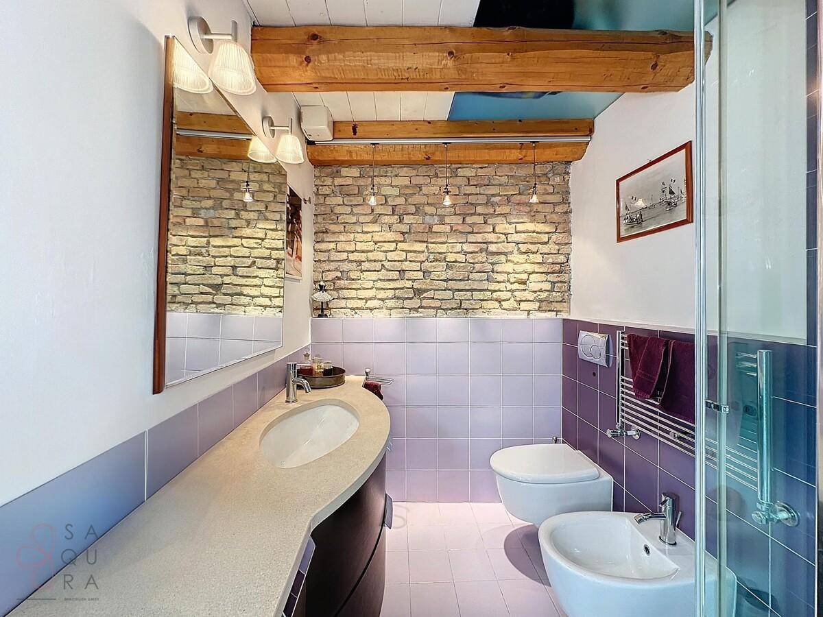 Modernes Badezimmer mit Einzelwaschbecken, Toilette, Bidet und Duschbereich.