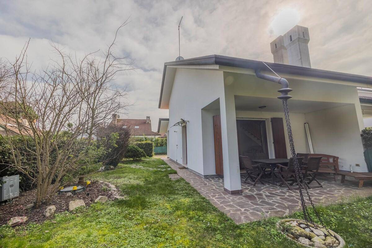 Überdachte Terrasse mit Gartenmöbeln und Blick auf den weitläufigen Gartenbereich.