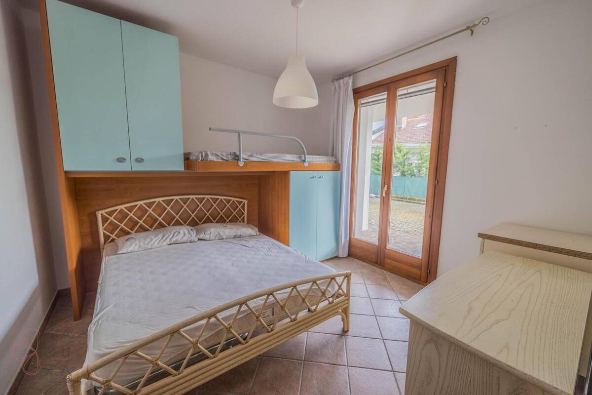 Schlafzimmer mit Etagenbett, Doppelbett und Zugang zu einem Außenbereich.