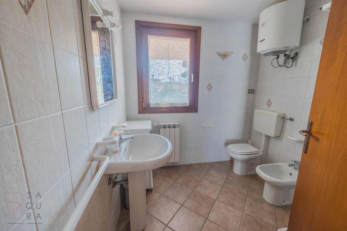 Badezimmer mit Waschbecken, Toilette, Bidet und Fenster.