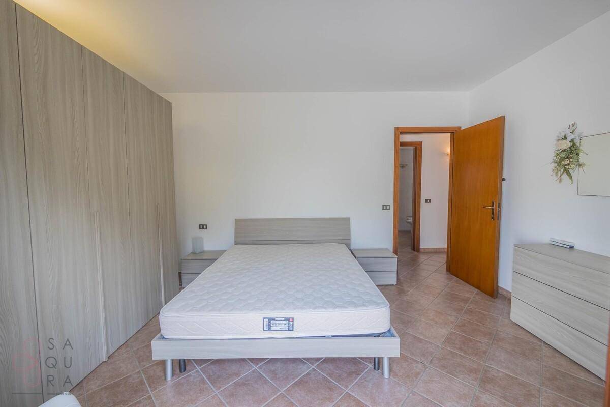 Schlafzimmer mit Doppelbett, Nachttischen und geräumigem Kleiderschrank.