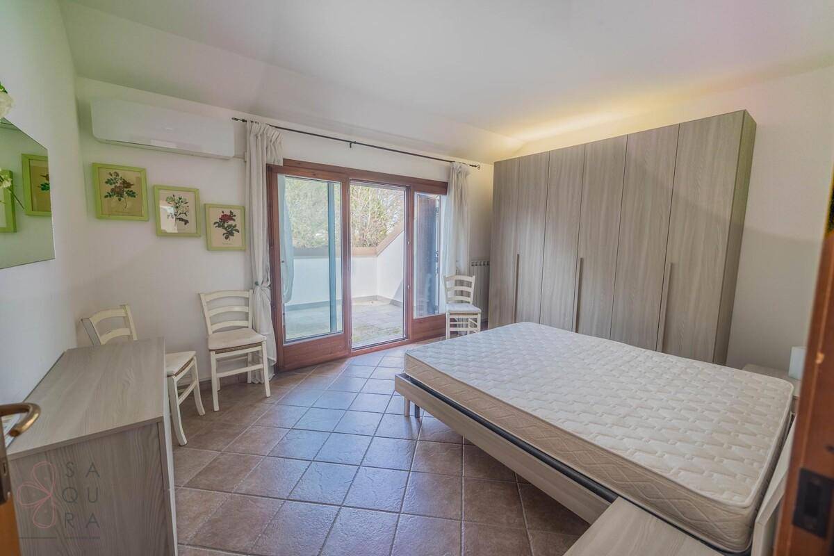 Helles Schlafzimmer mit großem Kleiderschrank und direktem Zugang zur Terrasse.