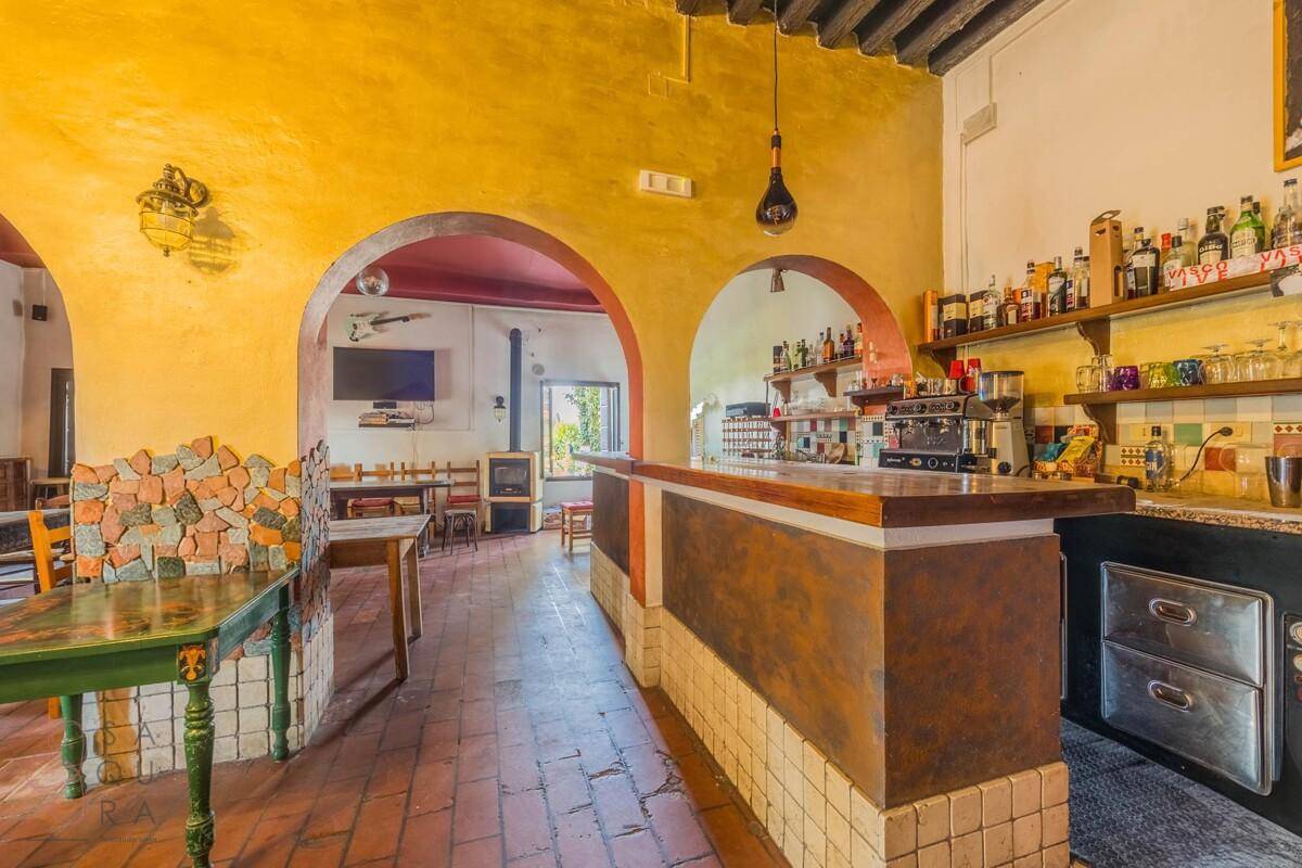 Detailansicht der rustikalen Bar mit Fliesenverkleidung und Kaffeemaschine im Gemeinschaftsraum.