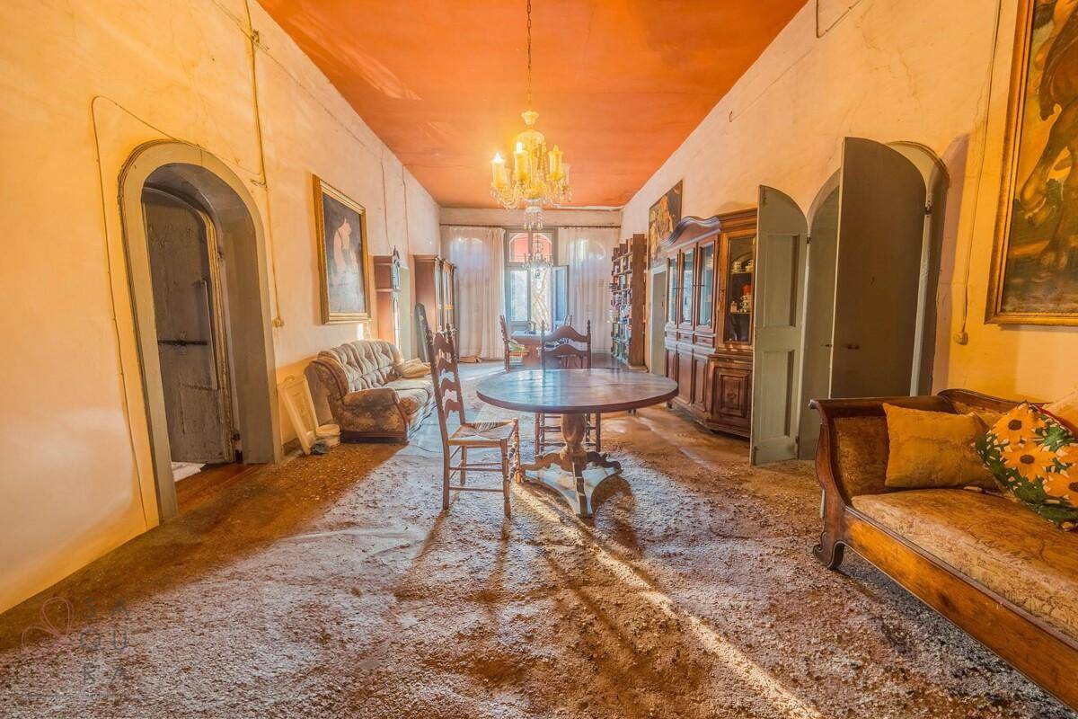Elegantes Esszimmer mit Kronleuchter, hohen Decken und traditionellen Holzmöbeln.