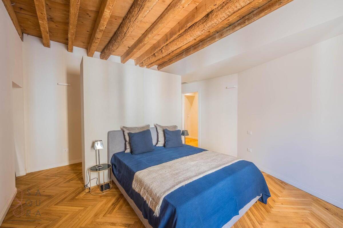 Schlafzimmer mit Holzbalkendecke, Fischgrätparkett und einem gemütlichen Doppelbett.