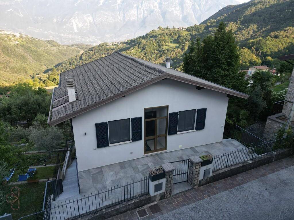Freistehendes Haus mit Satteldach, gepflasterter Terrasse und Bergblick in ländlicher Umgebung.