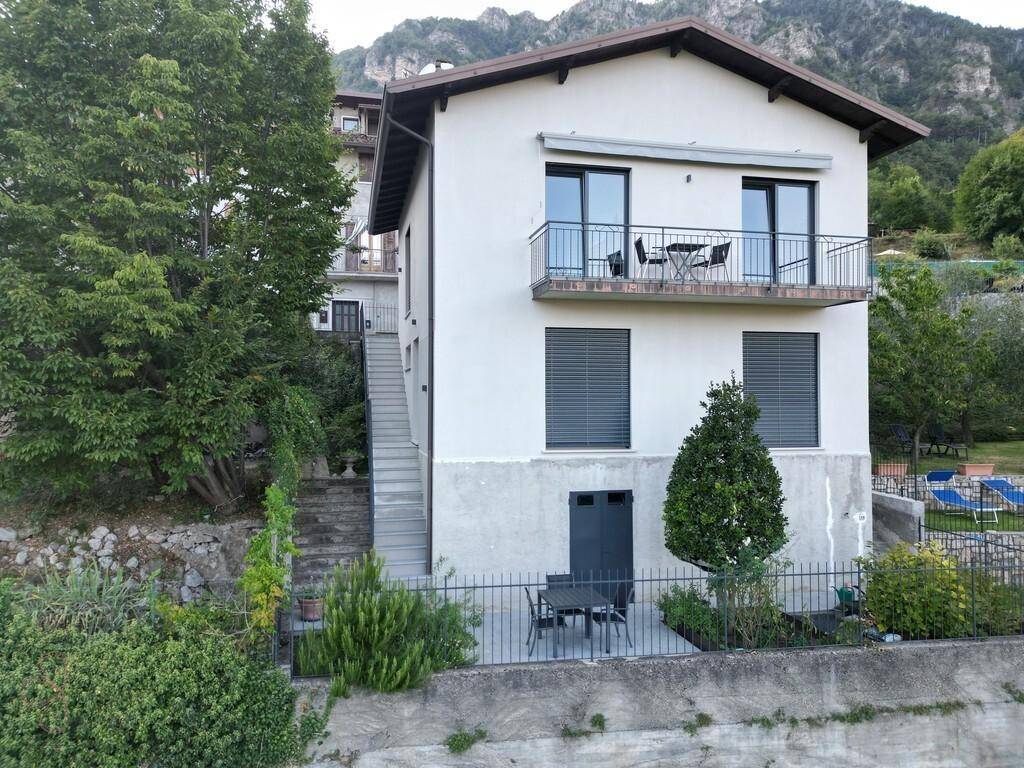 Mehrstöckiges Wohnhaus mit Balkonen, Terrasse und Blick auf die umliegende Berglandschaft.