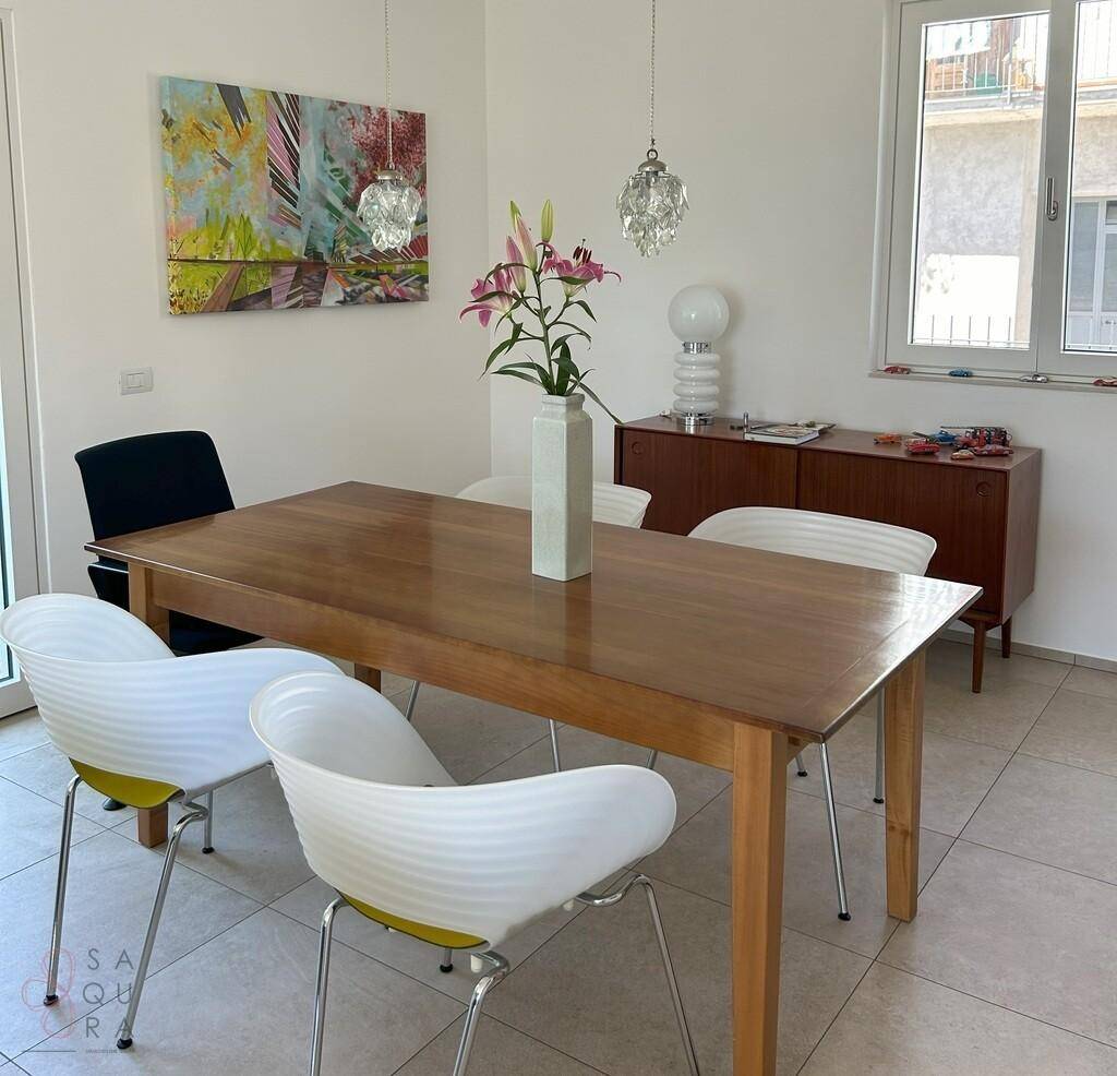 Heller Essbereich mit Holztisch, modernen Stühlen und dekorativer Kunst an der Wand.