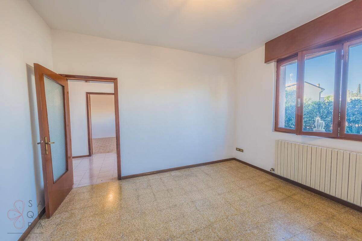 Heller Raum mit Terrazzoboden und Zugang zu weiteren Zimmern, ideal für flexible Nutzung.