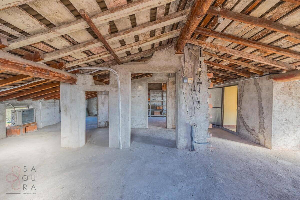 Geräumiger Dachboden mit sichtbarer Holzkonstruktion und Betonboden, bietet viel Stauraum.
