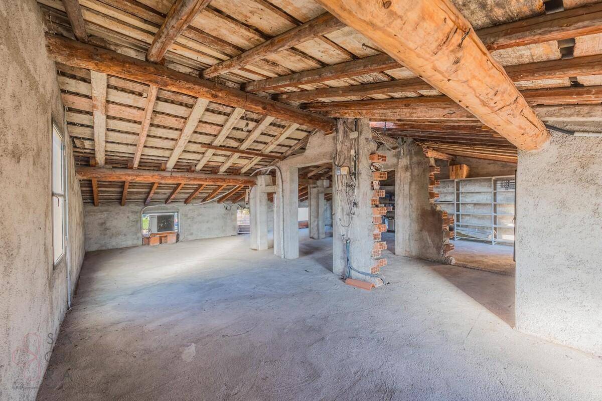 Großer Dachboden mit freiliegenden Holzbalken und Betonboden, ideal für zukünftige Erweiterungen.