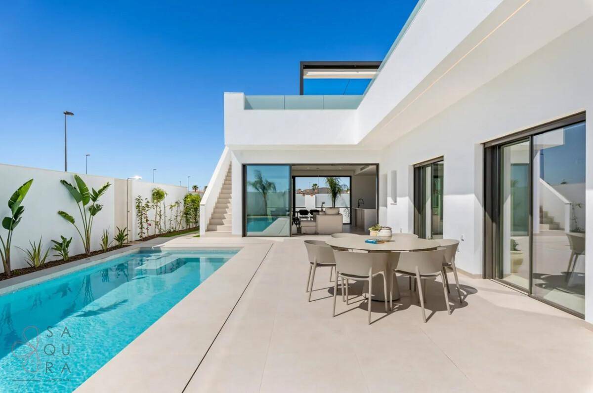 Elegante Villa mit großzügiger Poolterrasse und modernem Essbereich im Freien.