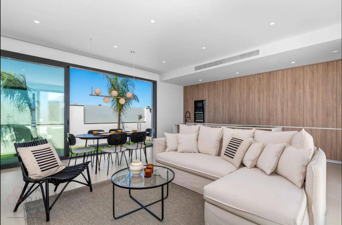 Heller Wohnbereich mit bequemer Couch und Essbereich, offen zur modernen Küche und Terrasse.