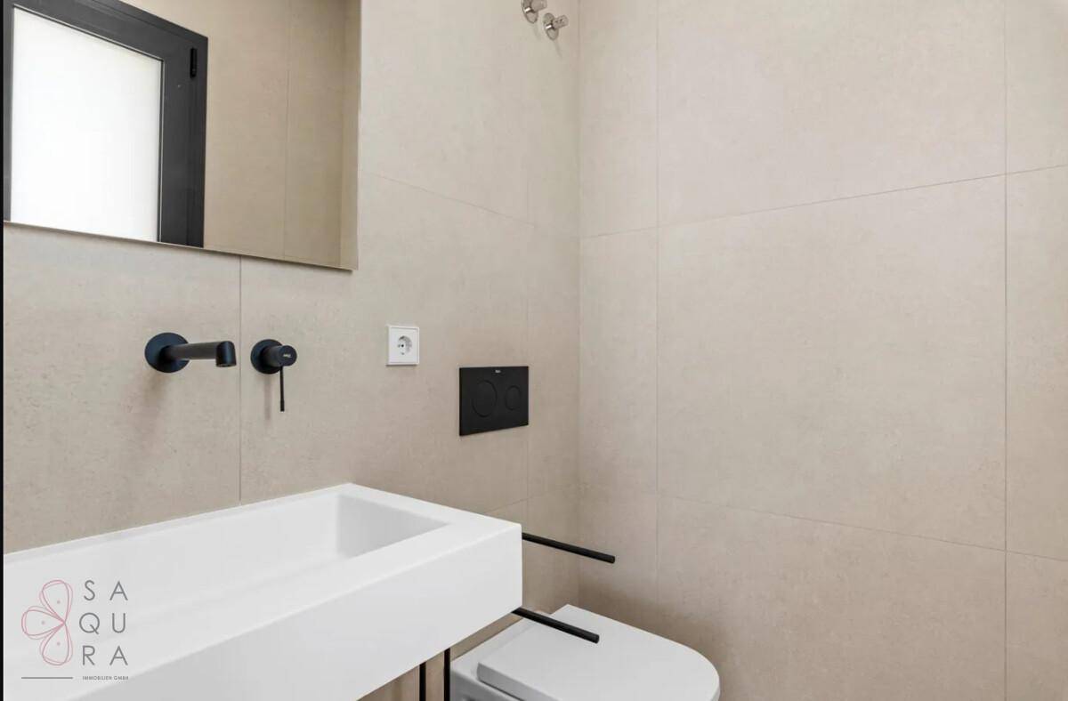 Modernes Badezimmer mit schwebendem Waschbecken und wandhängendem WC.
