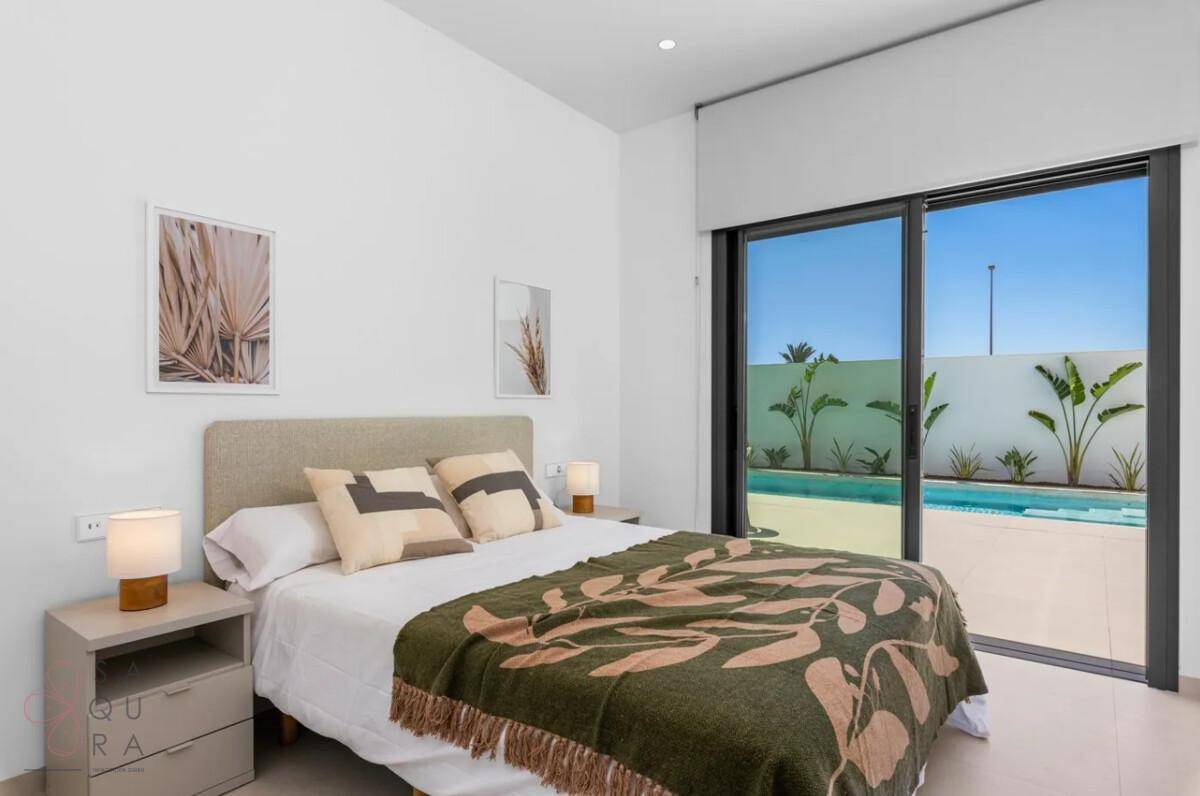 Komfortables Schlafzimmer mit Doppelbett und direktem Blick auf den privaten Pool.