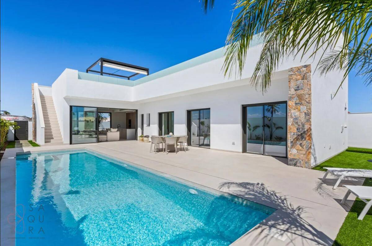 Elegante Villa mit großem Pool, Sonnenterrasse und modernem Design unter blauem Himmel.