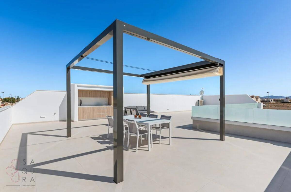 Geräumige Dachterrasse mit Pergola, Essbereich und Lounge-Möbeln unter blauem Himmel.