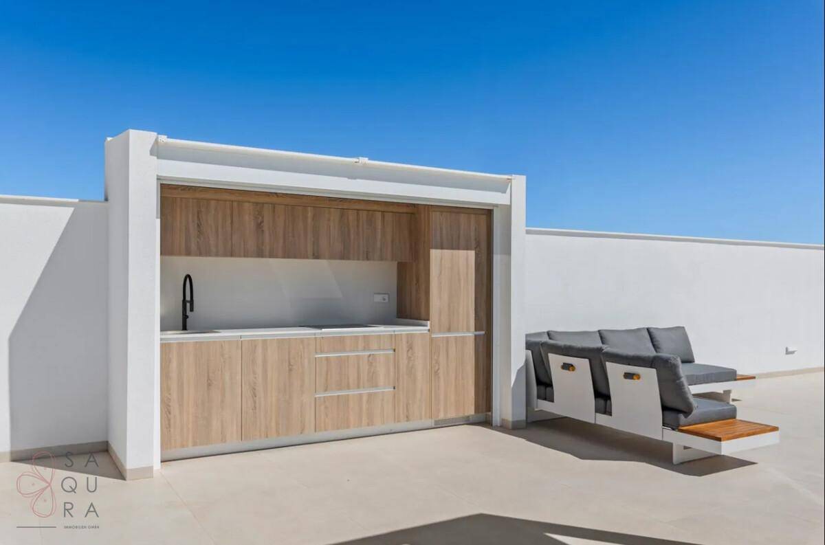 Moderne Außenküche auf der Dachterrasse mit Holzfronten und integriertem Spülbecken.