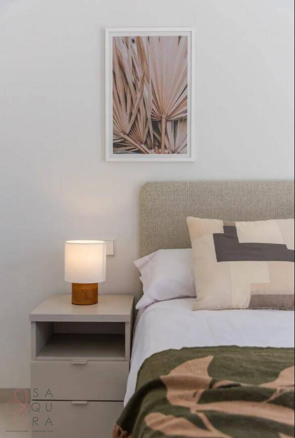 Gemütliches Schlafzimmer mit modernem Bett, Nachttisch und dezenter Wanddekoration.