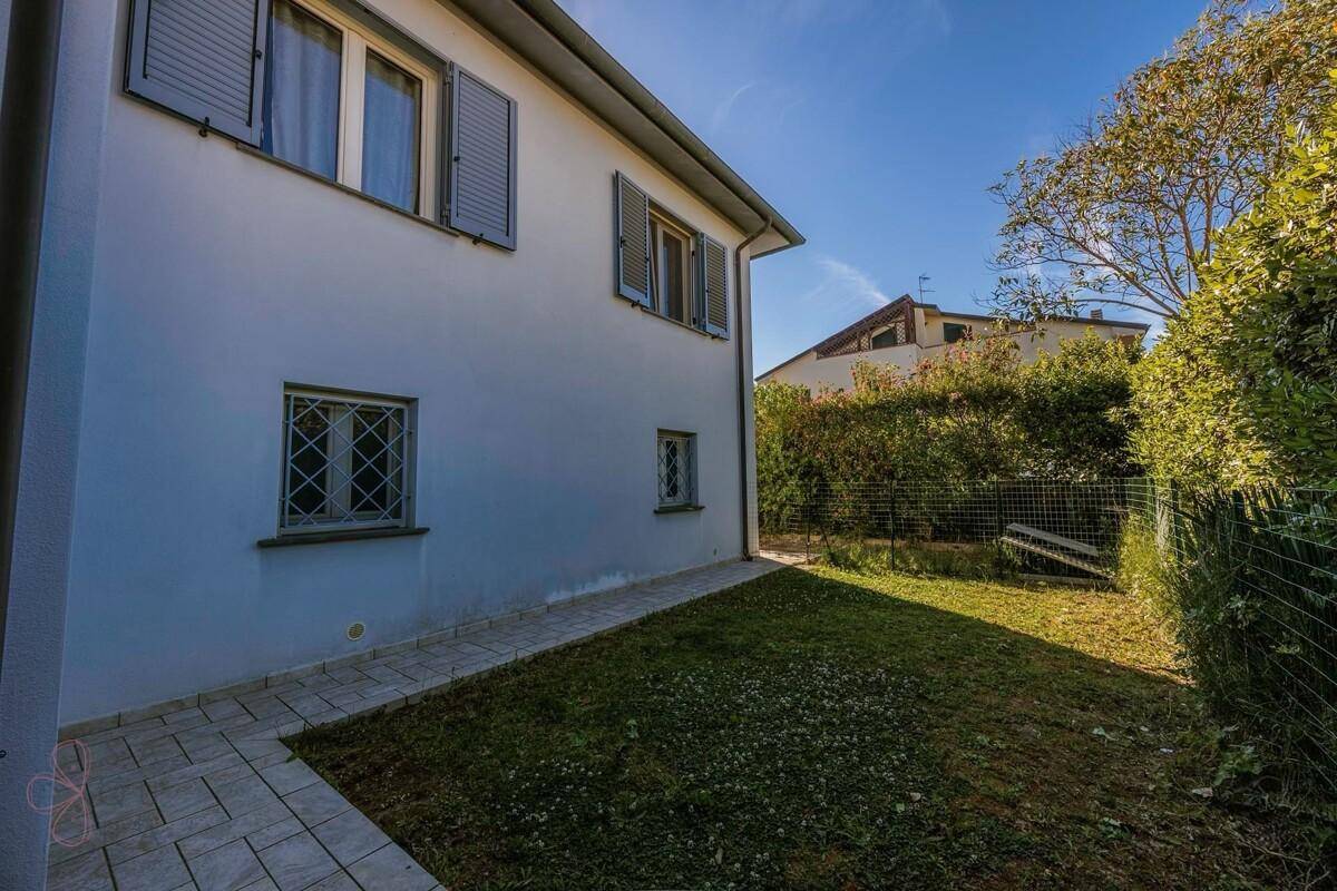 Seitenansicht des Hauses mit kleinem Rasenbereich und Blick auf die Nachbarschaft.