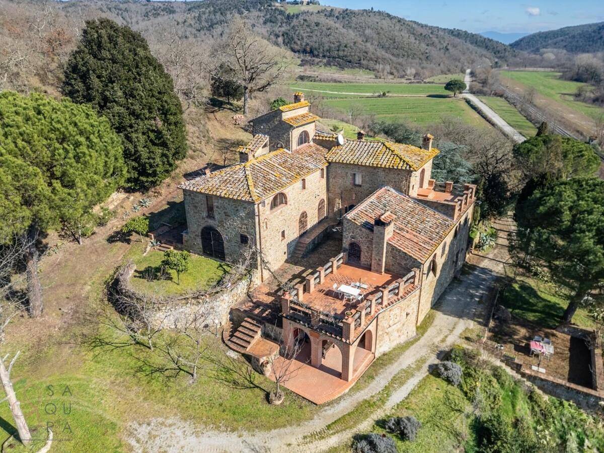 Panoramablick auf das historische Landhaus mit mehreren Terrassenbereichen und weitläufiger grüner Umgebung.