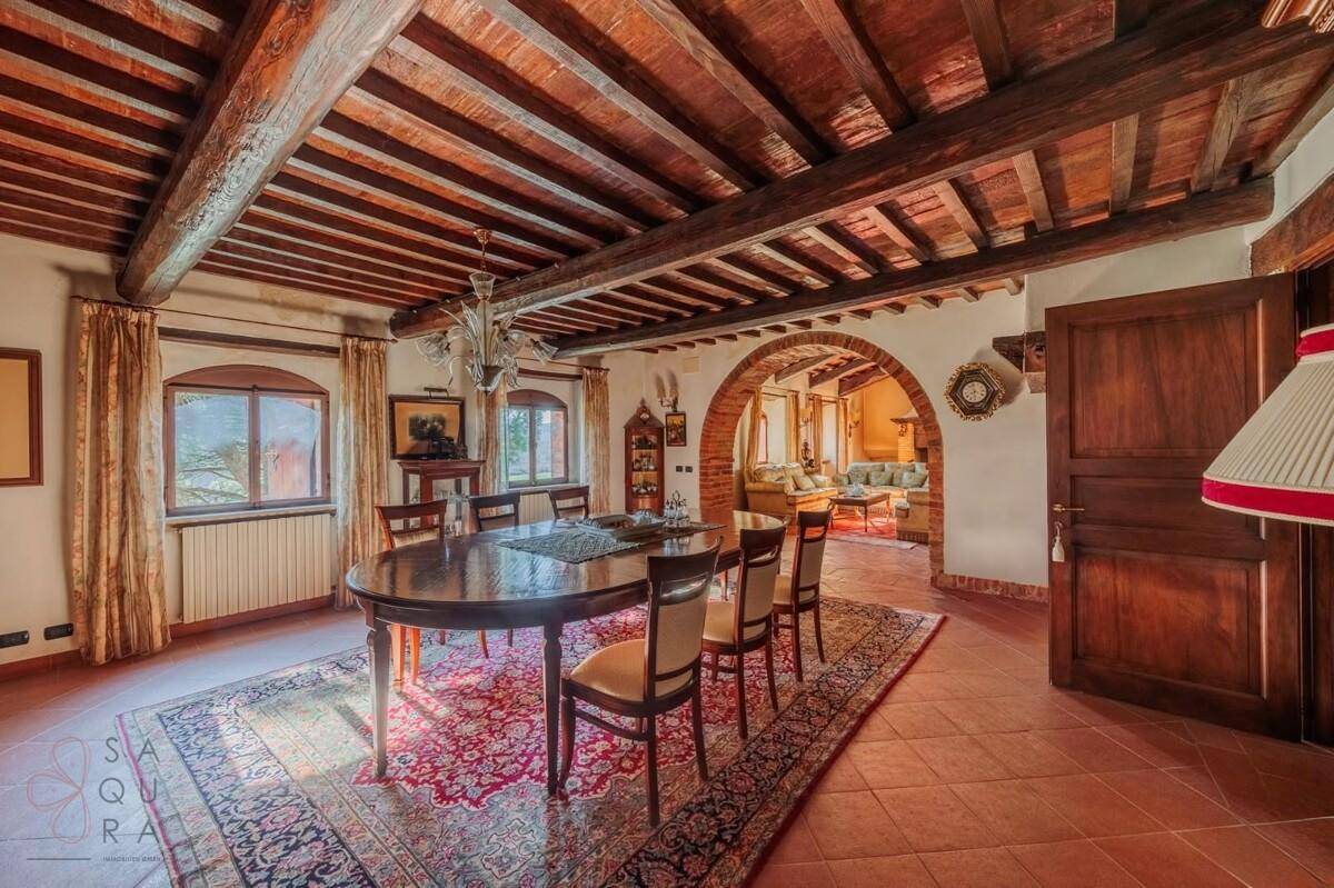 Eleganter Essbereich mit Holzbalkendecke, großem Esstisch und traditionellem Teppichboden.