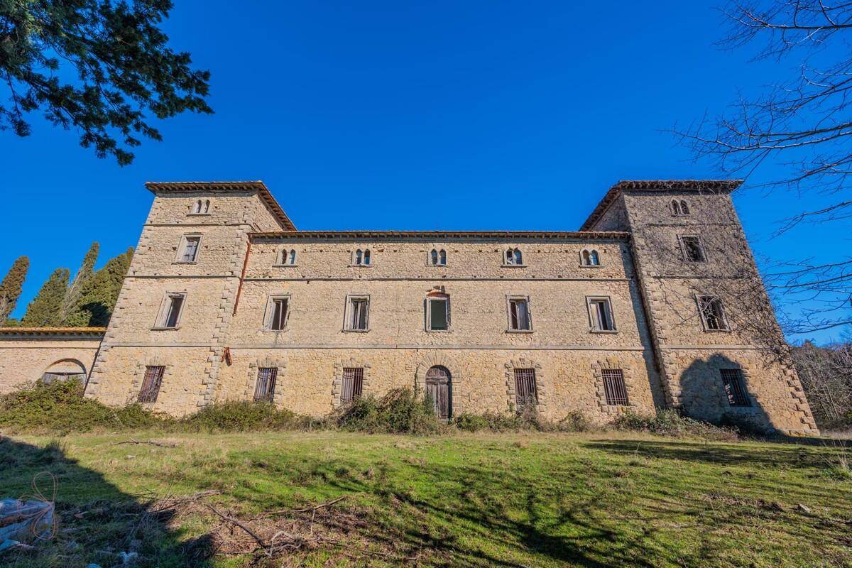 Beeindruckende Steinfassade des historischen Anwesens mit zahlreichen Fenstern und zwei Türmen.