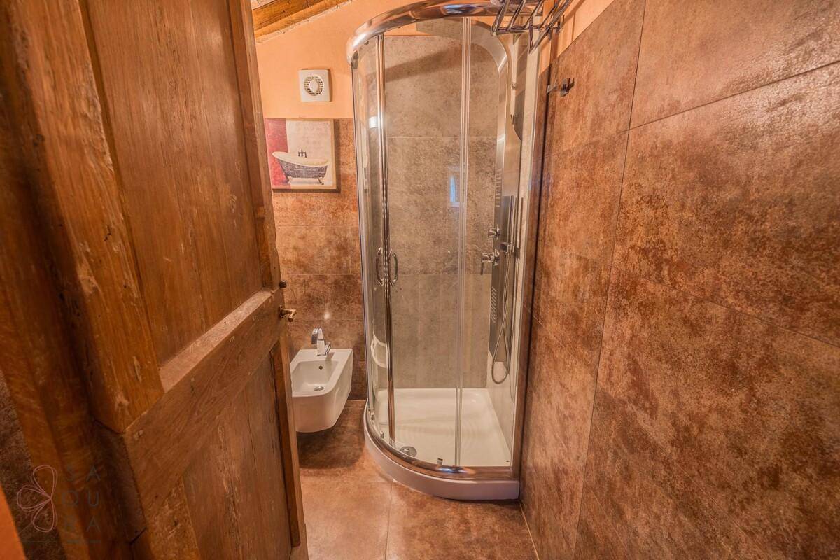 Badezimmer mit braunen Fliesen, Dusche und Bidet.