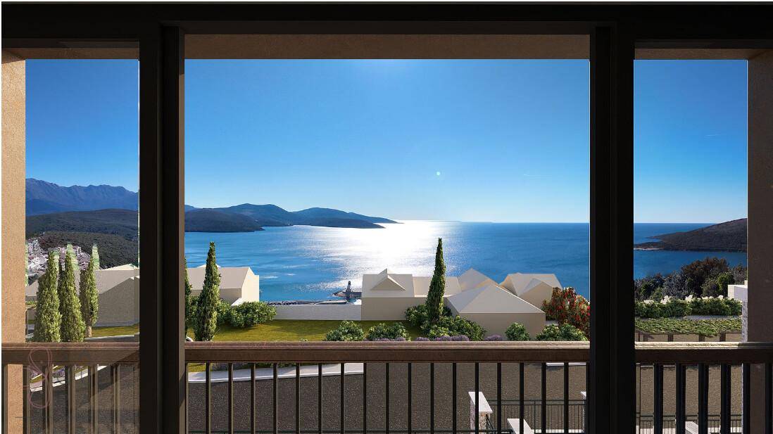 Panoramablick aus dem Fenster auf das glitzernde Meer, die umliegenden Berge und weitere Gebäude.