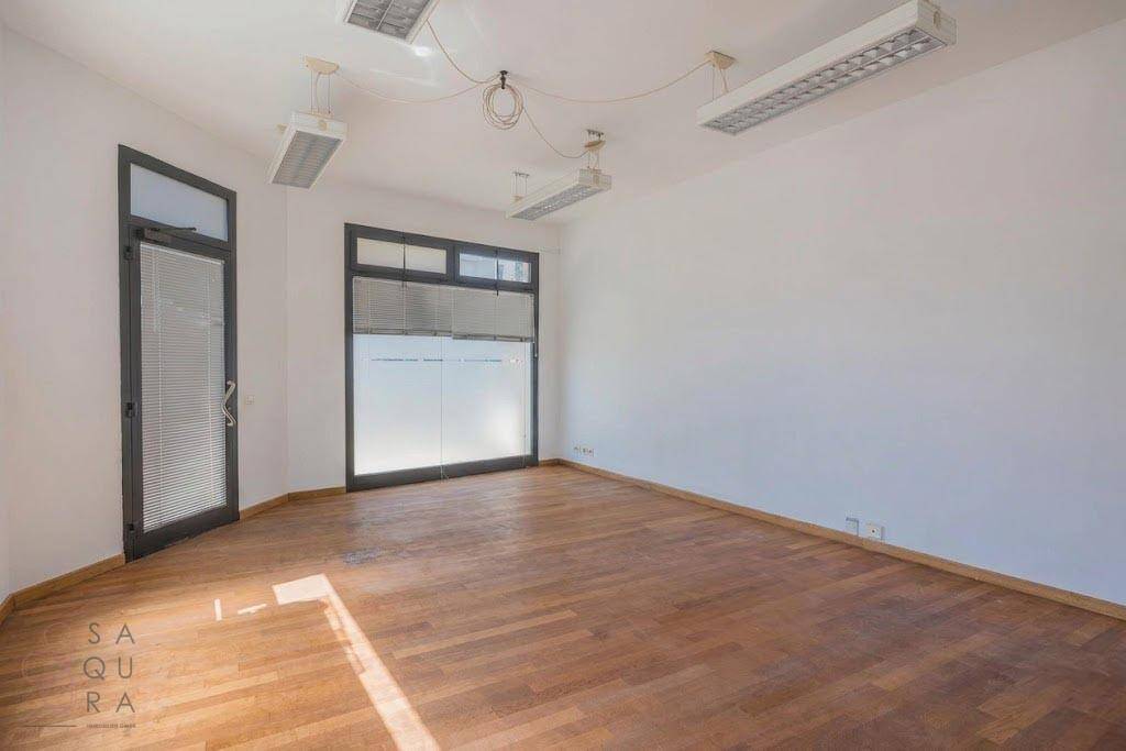 Geräumiger Raum mit Holzboden und großen Fenstern, geeignet für gewerbliche Nutzung oder Büro.
