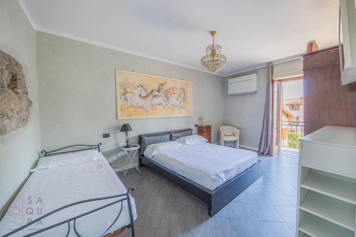Geräumiges Schlafzimmer mit Doppel- und Einzelbett, Klimaanlage und Balkonzugang.
