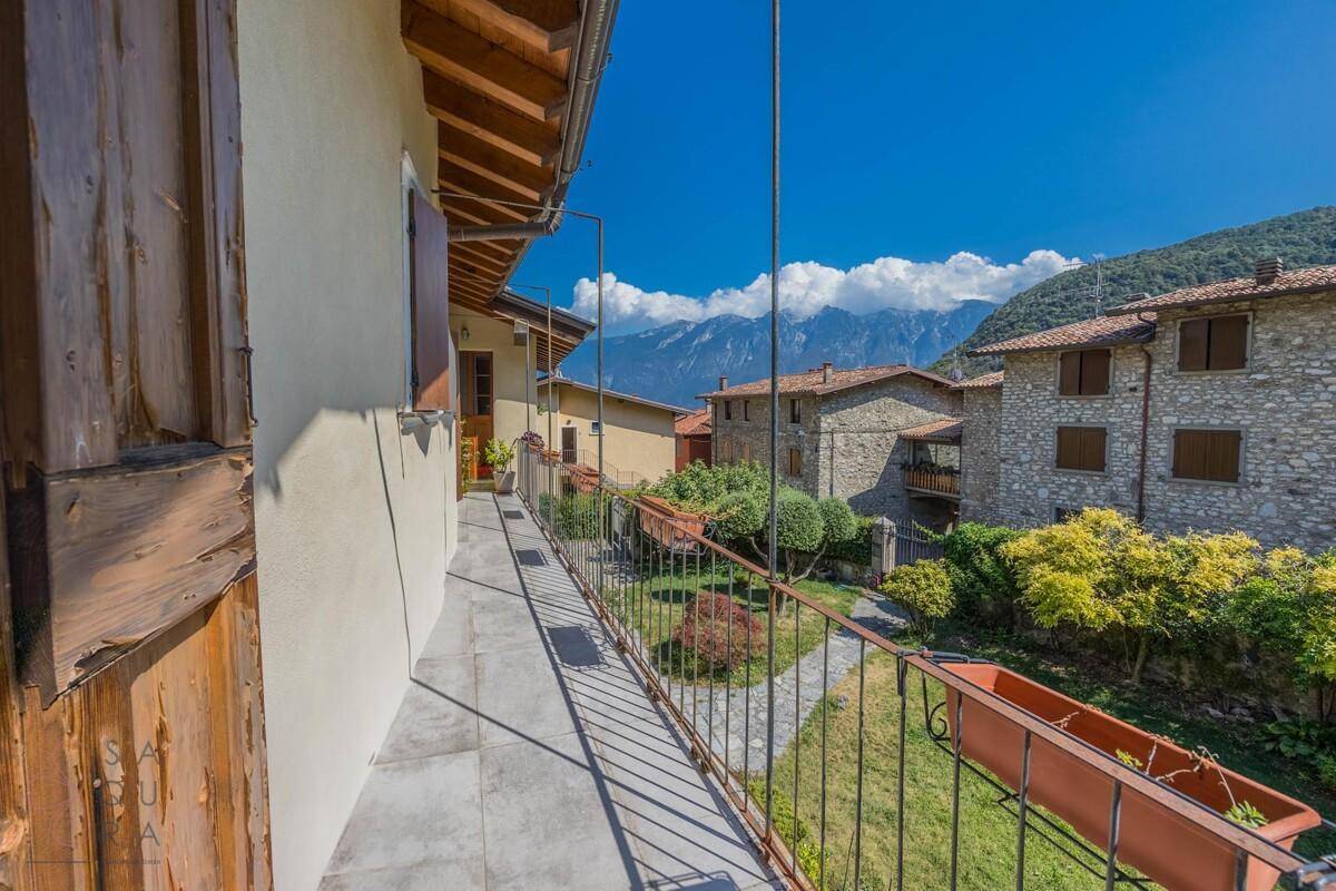 Langer Balkon mit Metallgeländer und weitem Blick auf die Berge und die Umgebung.